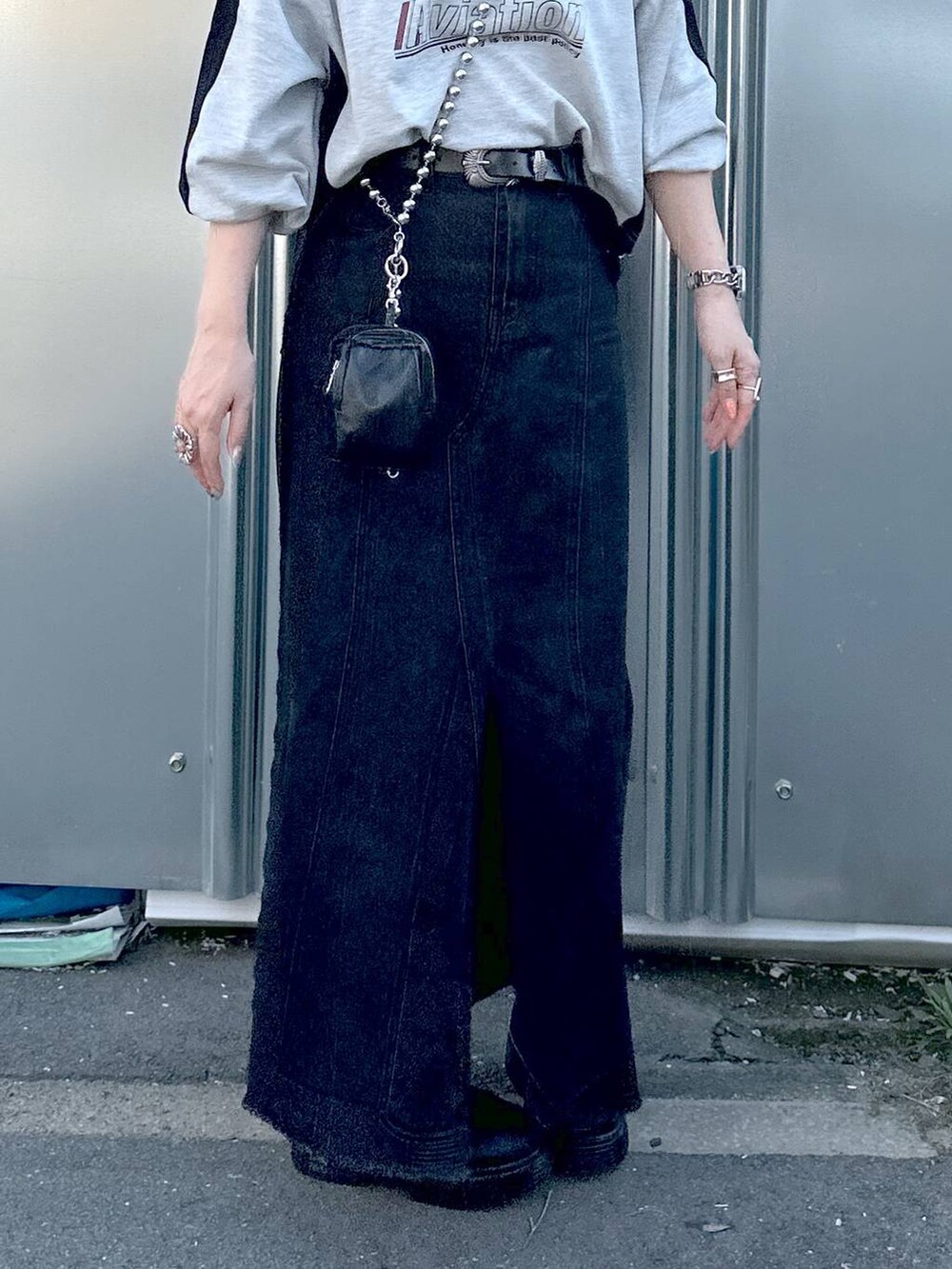 ブラック系のデニムスカート、グレー系のTシャツ/カットソー、ブラック系のブーツを着用したレディースの秋コーディネートの8枚目の写真