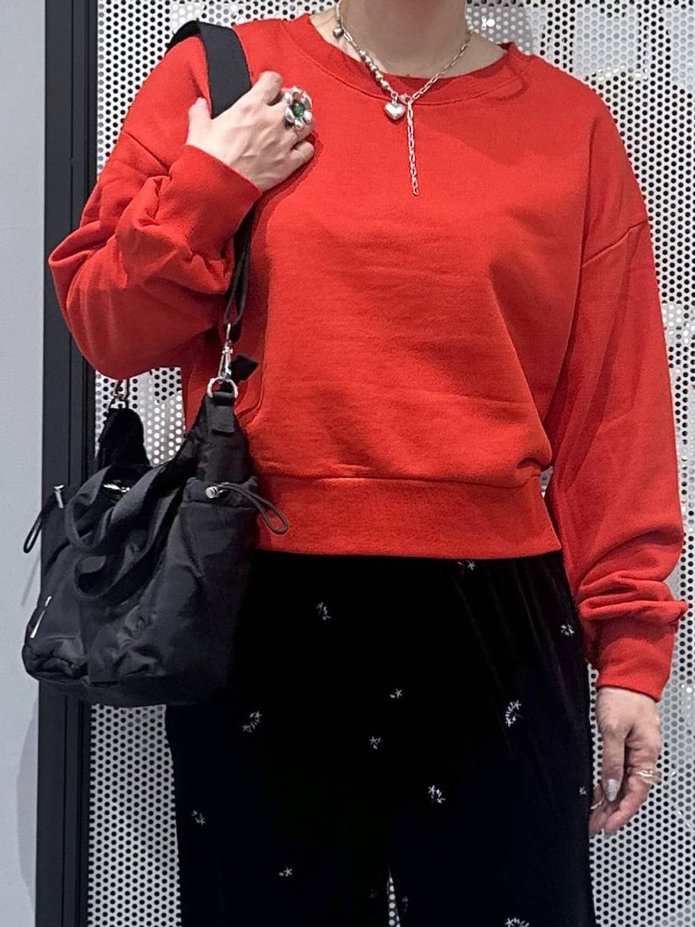 ブラック系のトートバッグ、ブラック系のその他パンツ、レッド系のスウェットを着用したレディースの秋コーディネートの4枚目の写真