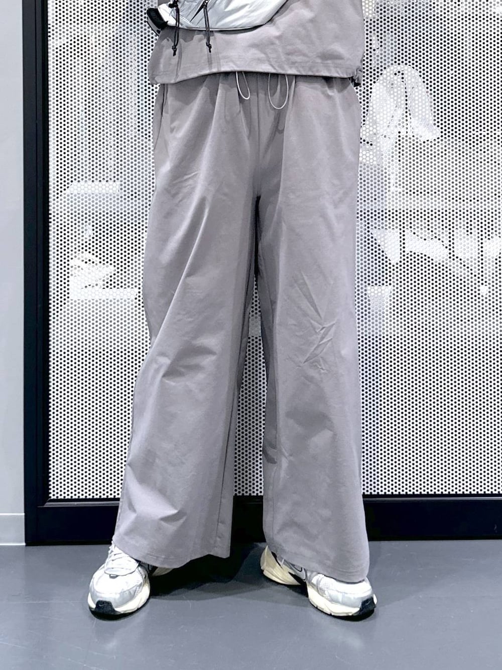 シルバー系のボディバッグ/ウエストポーチ、グレー系のTシャツ/カットソー、グレー系のその他パンツを着用したレディースの春コーディネートの4枚目の写真