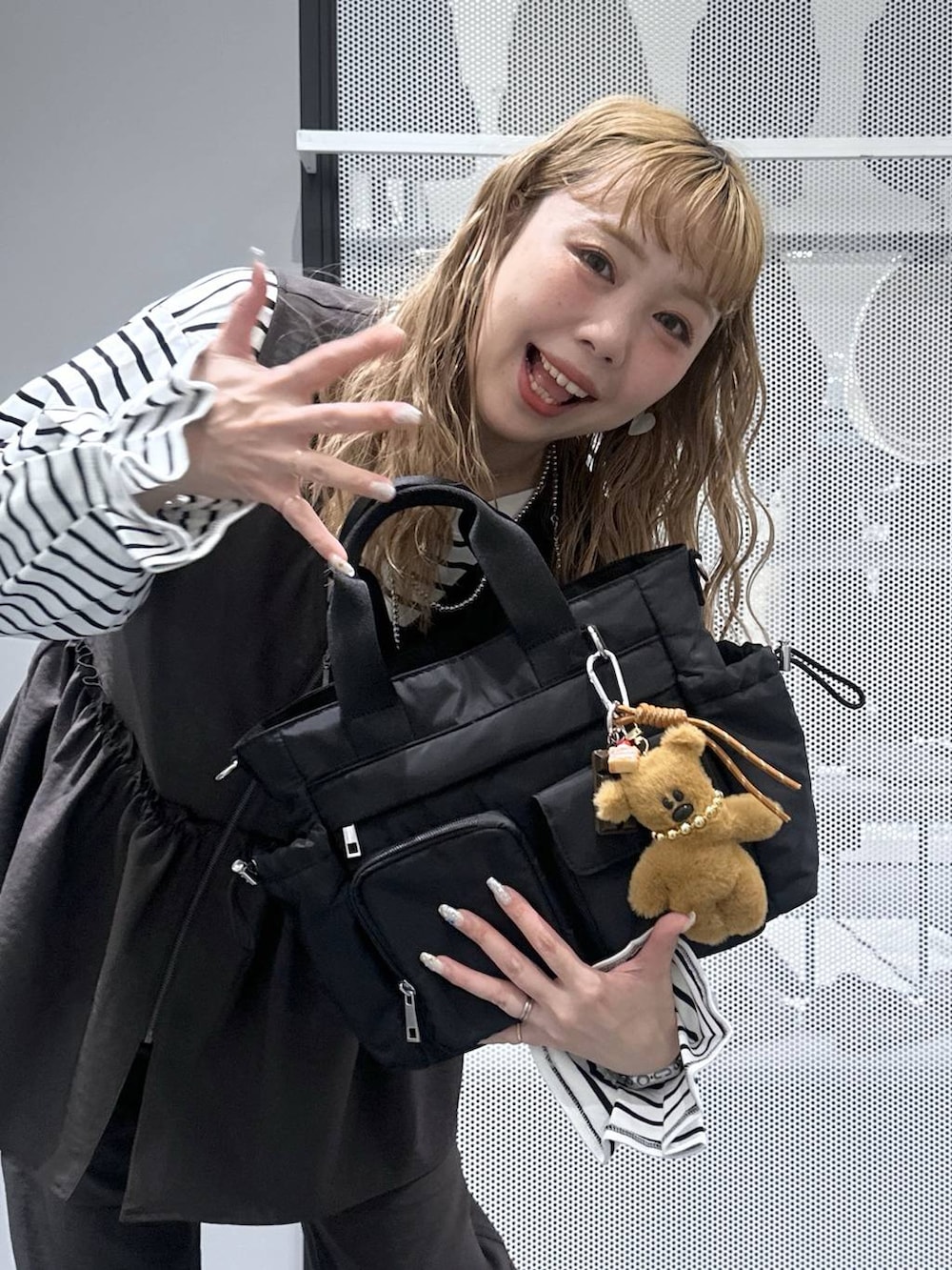 グレー系のその他パンツ、ブラック系のトートバッグ、ベージュ系のスニーカーを着用したレディースの春コーディネートの6枚目の写真