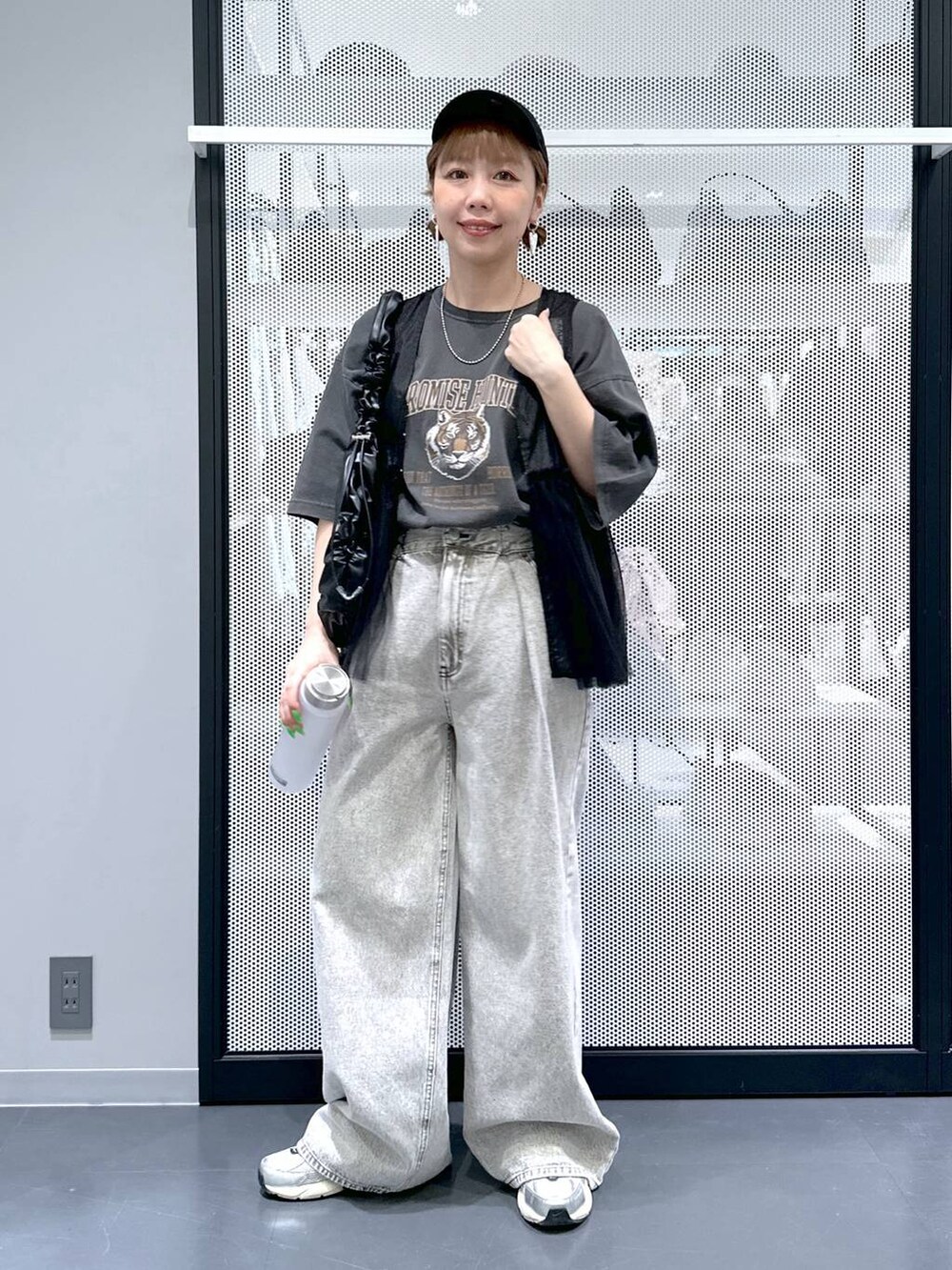 グレー系のデニムパンツ、ブラック系のベスト、グレー系のTシャツ/カットソーを着用したレディースの春コーディネートの2枚目の写真