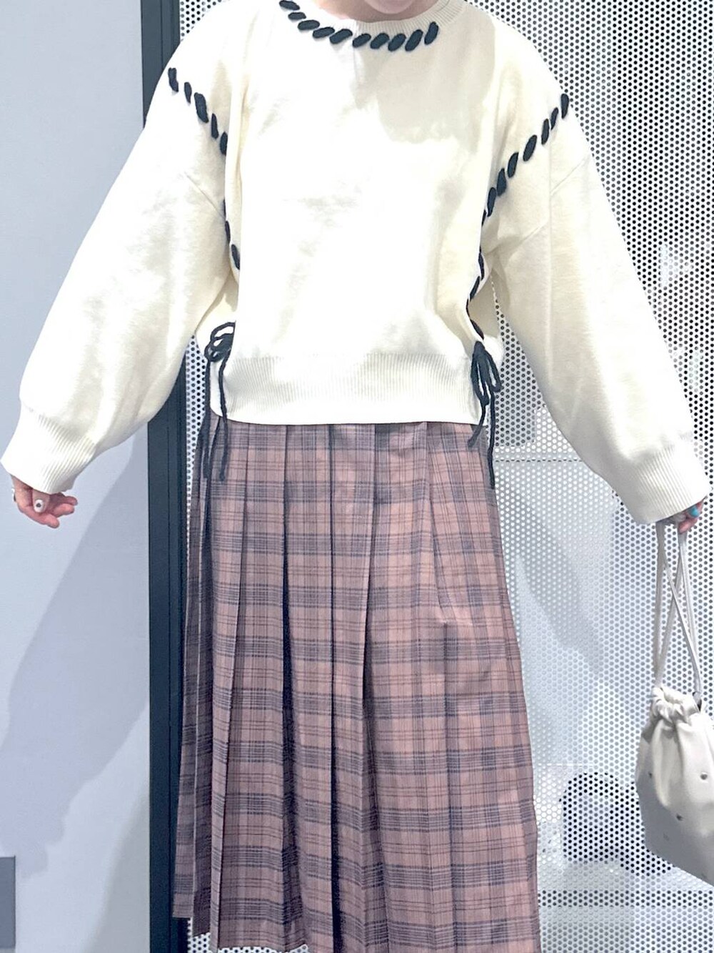 ホワイト系のショルダーバッグ、ブラック系のブルゾン、ブラウン系のブーツを着用したレディースの秋コーディネートの6枚目の写真