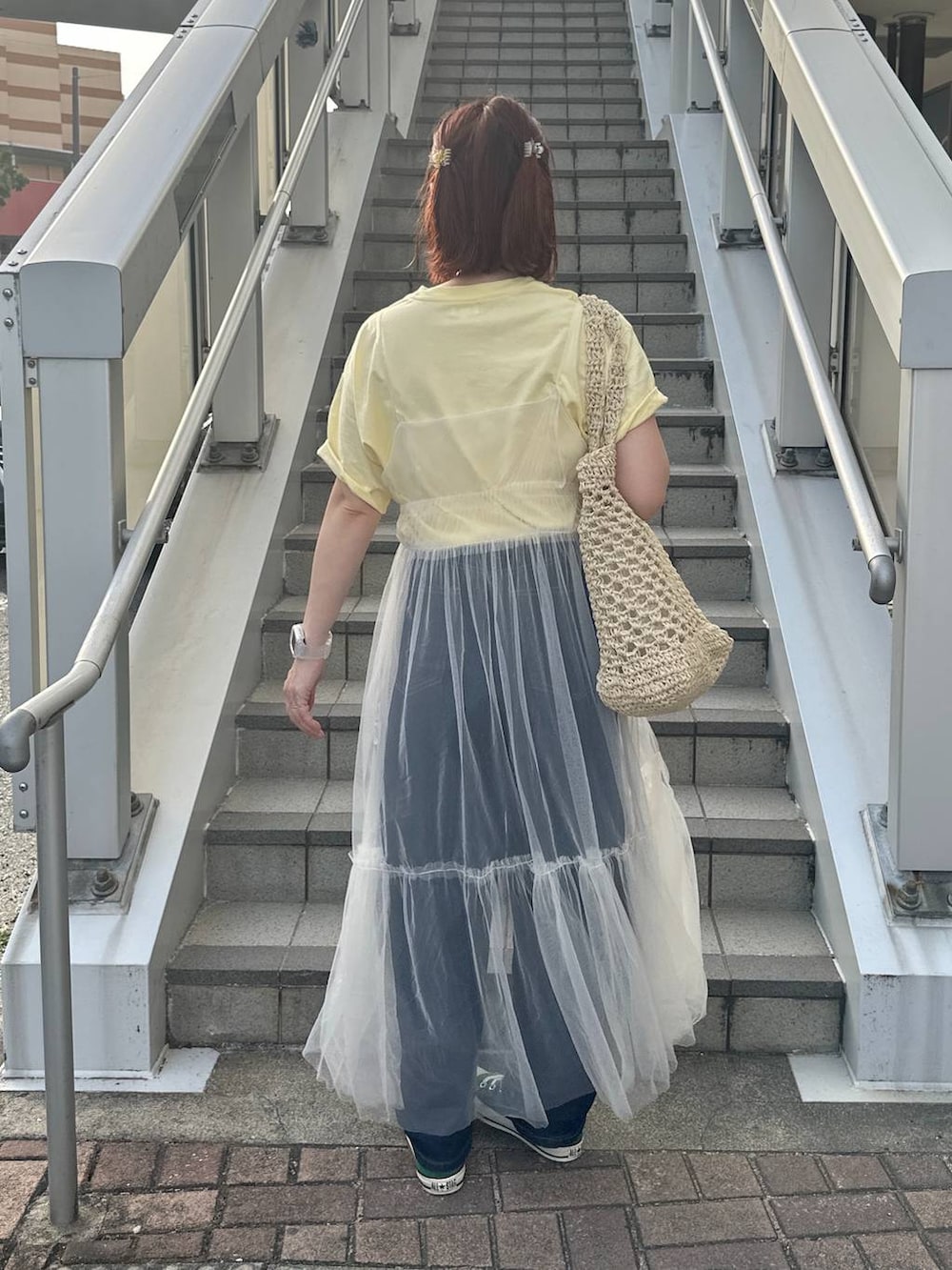 グリーン系のスニーカー、ホワイト系のトートバッグ、ベージュ系のTシャツ/カットソーを着用したレディースの春コーディネートの3枚目の写真