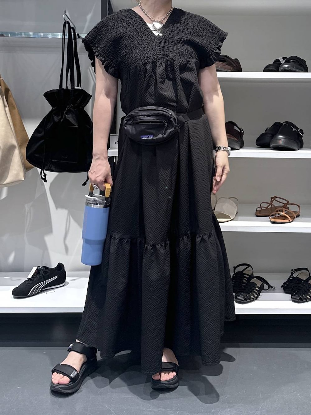 ブラック系のワンピース、シルバー系のデジタル腕時計、オレンジ系の水筒を着用したレディースの夏コーディネートの5枚目の写真