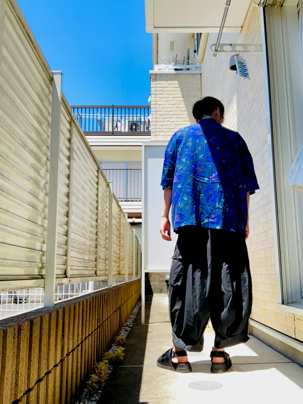 ブルー系のシャツ/ブラウス、ブラック系のその他パンツ、ブラック系のサンダルを着用したメンズの夏コーディネートの2枚目の写真