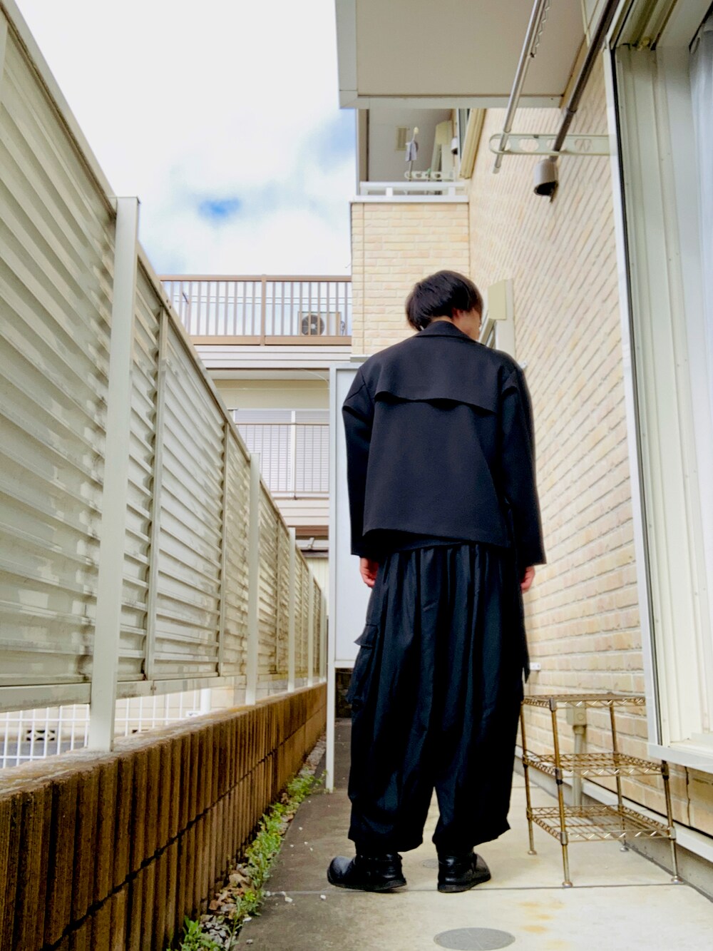 ブラック系のブルゾン、ブラック系のTシャツ/カットソー、ブラック系のその他パンツを着用したメンズの春コーディネートの2枚目の写真