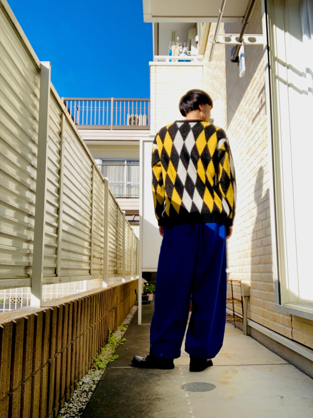 ブラック系のニット/セーター、ブルー系のその他パンツ、ブラック系のブーツを着用したメンズの冬コーディネートの2枚目の写真