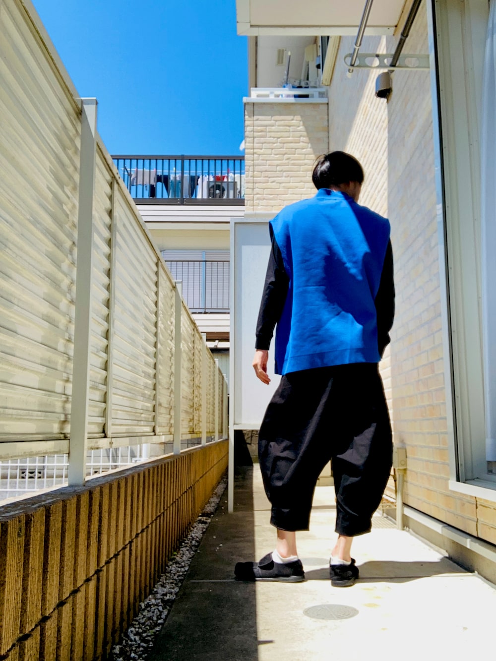 ブルー系のベスト、ブラック系のTシャツ/カットソー、ブラック系のその他パンツを着用したメンズの春コーディネートの2枚目の写真