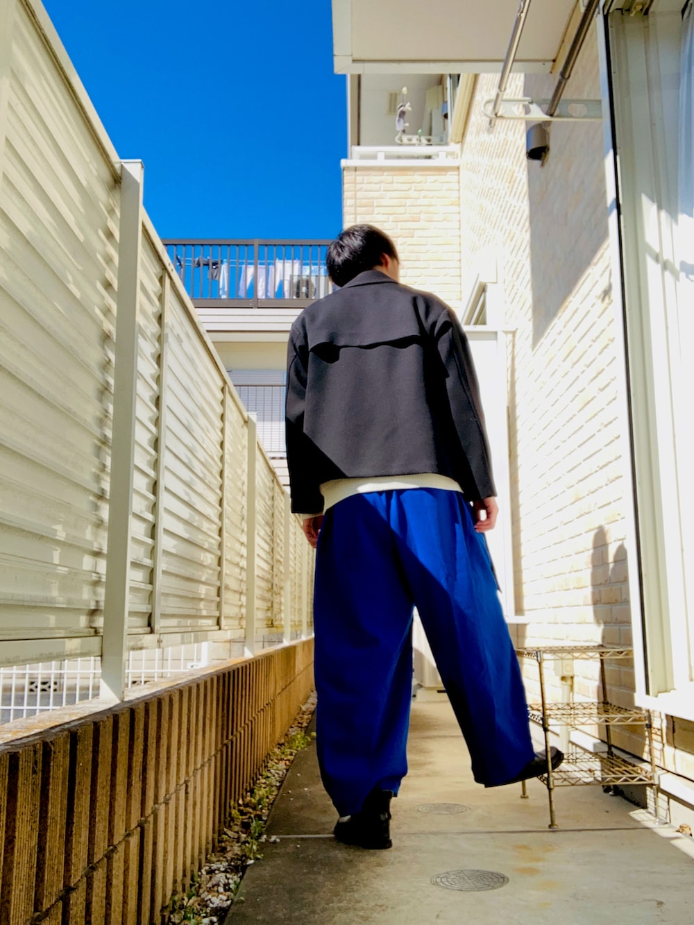 ブラック系のブルゾン、ホワイト系のニット/セーター、ブルー系のその他パンツを着用したメンズの冬コーディネートの2枚目の写真