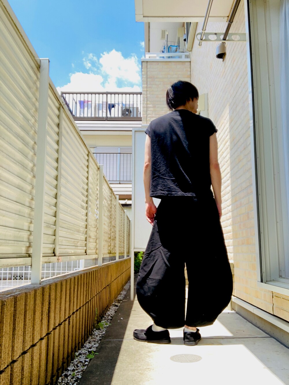 ブラック系のシャツ/ブラウス、ブラック系のスラックス、ブラック系のスニーカーを着用したメンズの夏コーディネートの2枚目の写真