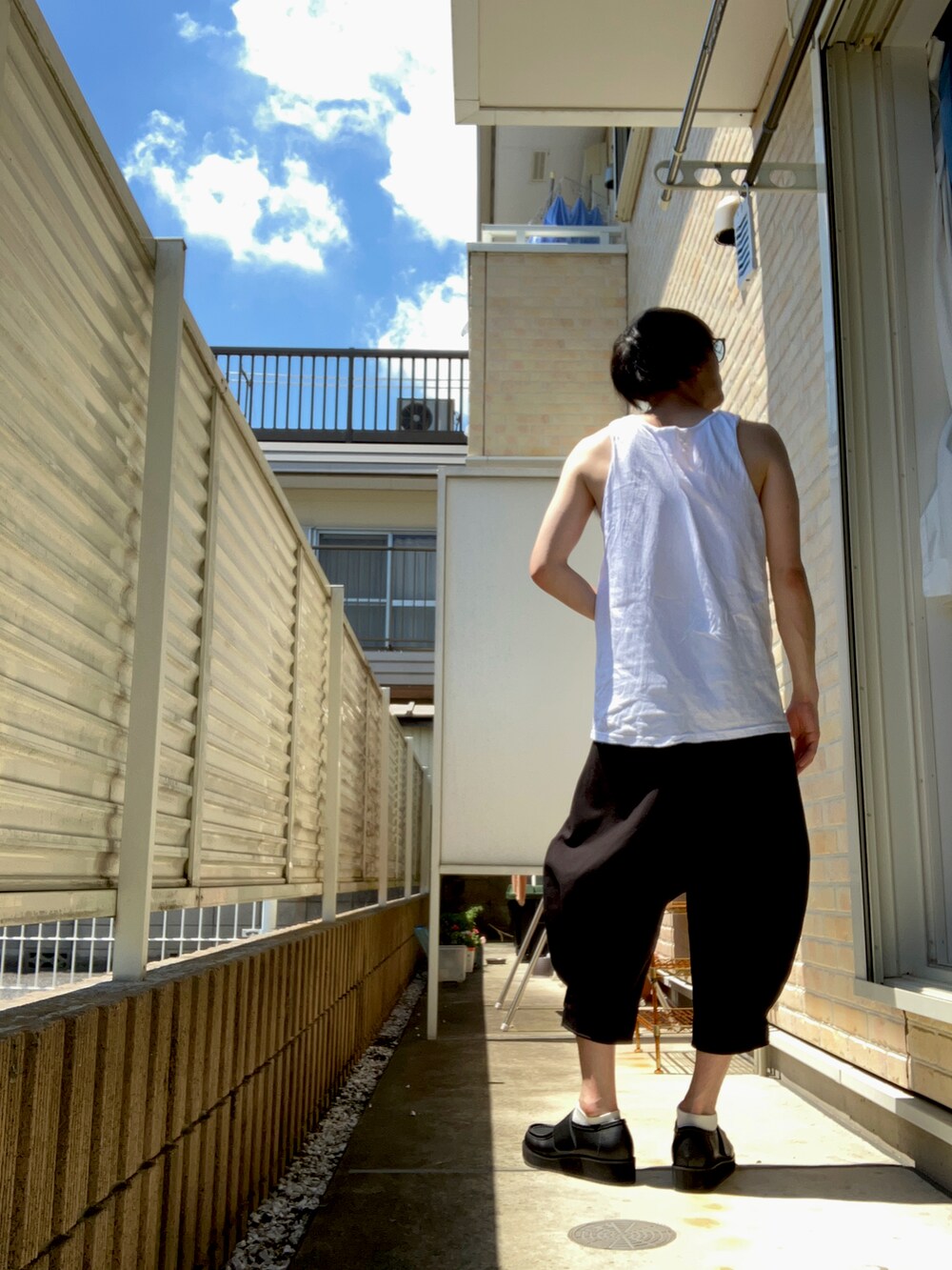 ホワイト系のタンクトップ、ブラック系のその他パンツ、ブラック系のスニーカーを着用したメンズの夏コーディネートの2枚目の写真