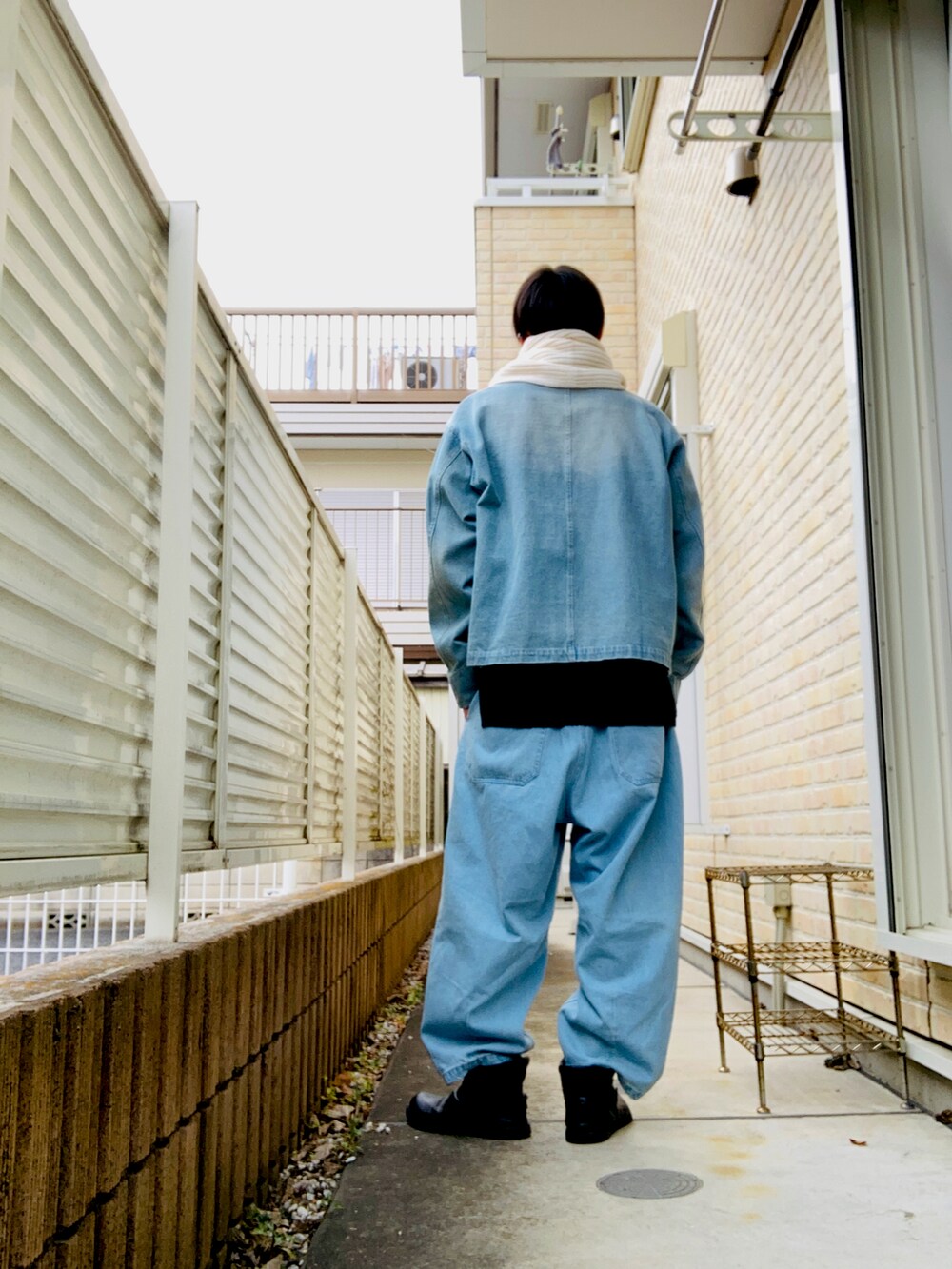 ブルー系のカバーオール、ブラック系のニット/セーター、ブルー系のその他パンツを着用したメンズの冬コーディネートの2枚目の写真