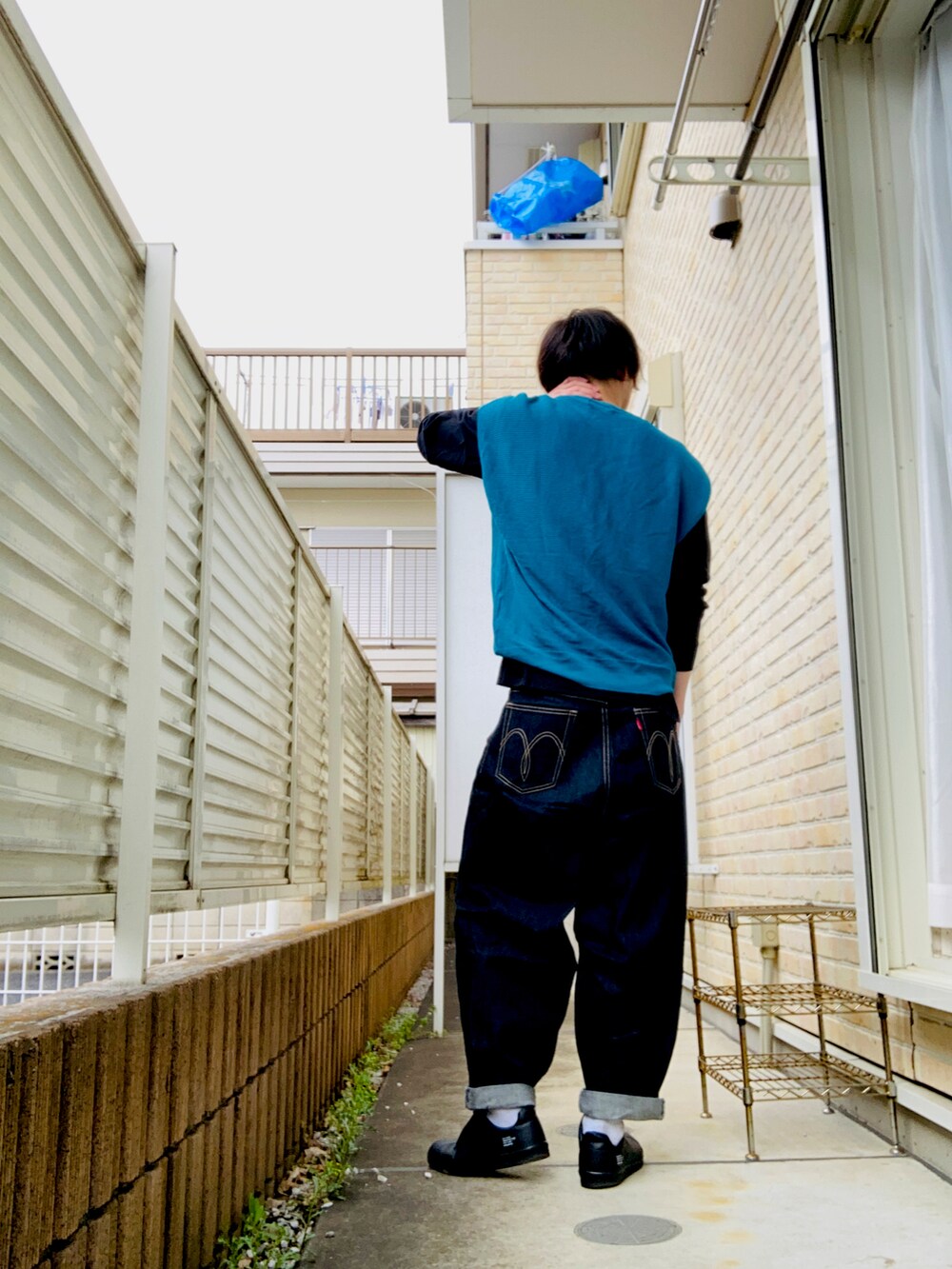 ブルー系のベスト、ブラック系のTシャツ/カットソー、ブルー系のデニムパンツを着用したメンズの春コーディネートの2枚目の写真