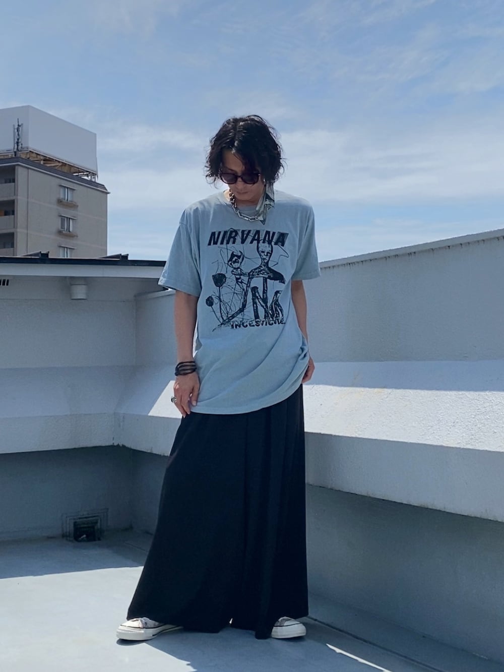 グリーン系のTシャツ/カットソー、ブラック系のスラックス、ベージュ系のスニーカーを着用したメンズの夏コーディネートの3枚目の写真