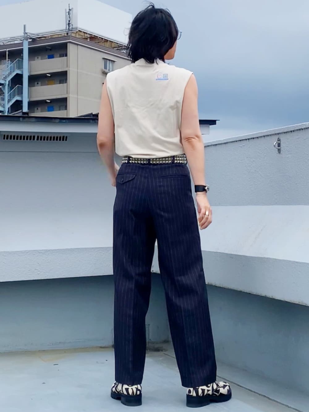 ベージュ系のTシャツ/カットソー、グレー系のスラックス、ホワイト系のドレスシューズを着用したメンズの夏コーディネートの3枚目の写真