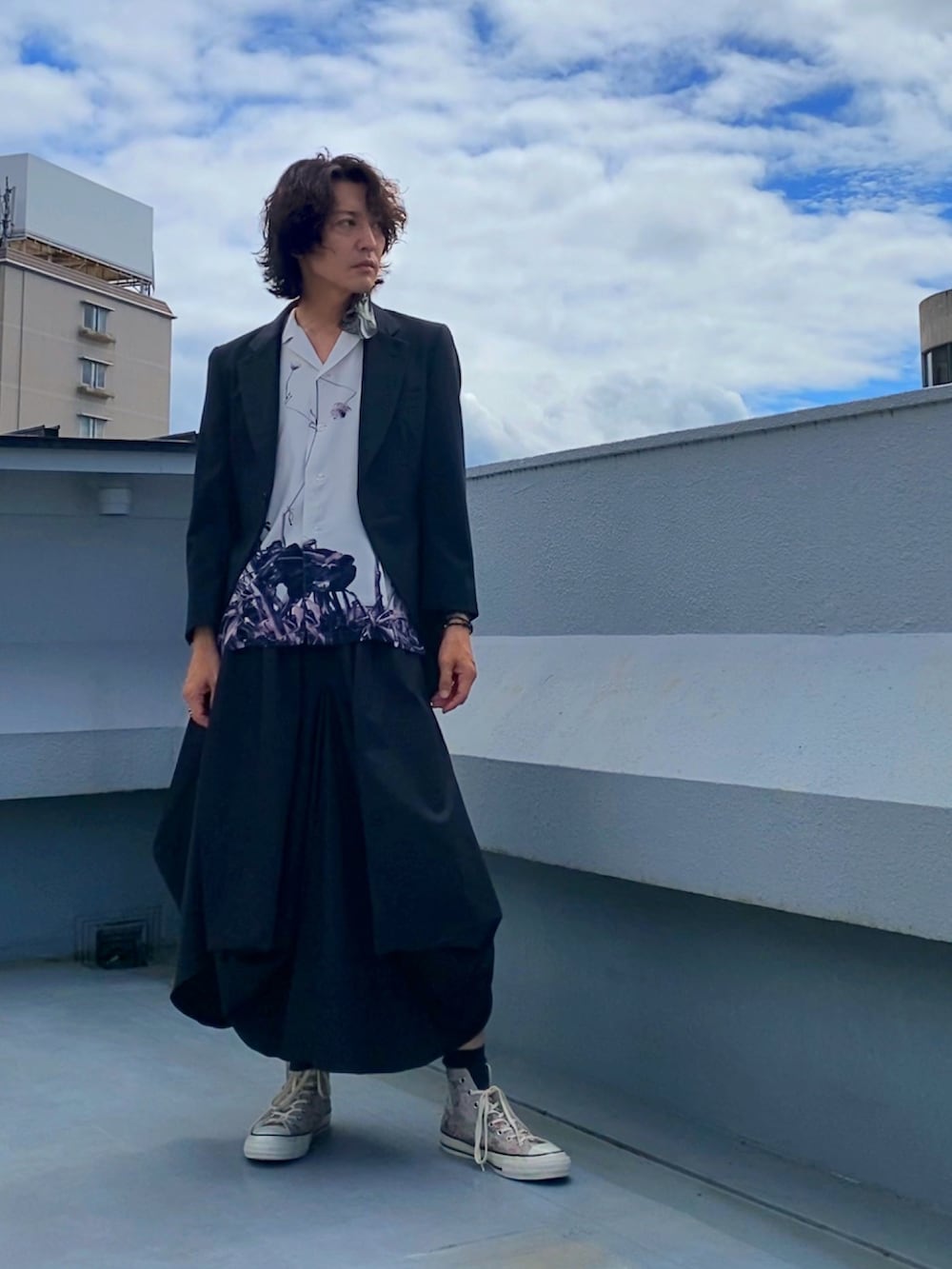 ブラック系のテーラードジャケット、ホワイト系のシャツ/ブラウス、ブラック系のスカートを着用したメンズの秋コーディネートの2枚目の写真