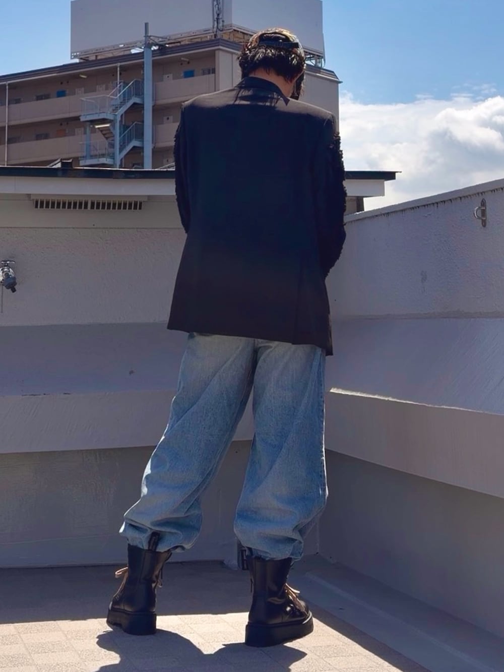 ブラック系のブーツ、ブルー系のデニムパンツ、ブラック系のTシャツ/カットソーを着用したメンズの春コーディネートの3枚目の写真