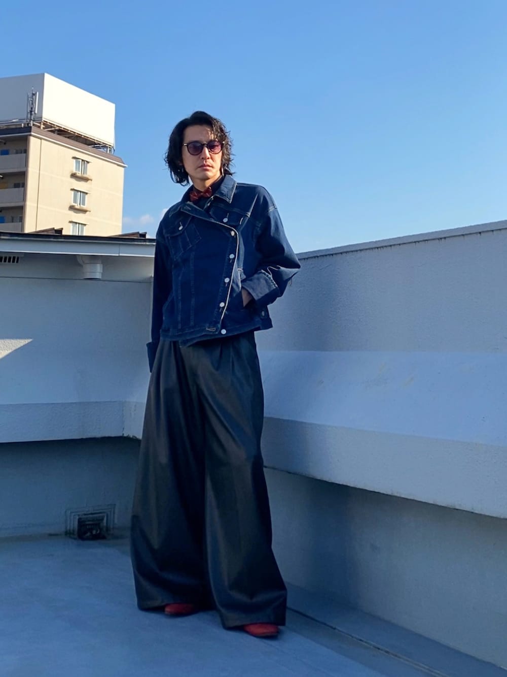 レッド系の蝶ネクタイ、ブルー系のデニムジャケット、ブラック系のその他パンツを着用したメンズの秋コーディネートの4枚目の写真