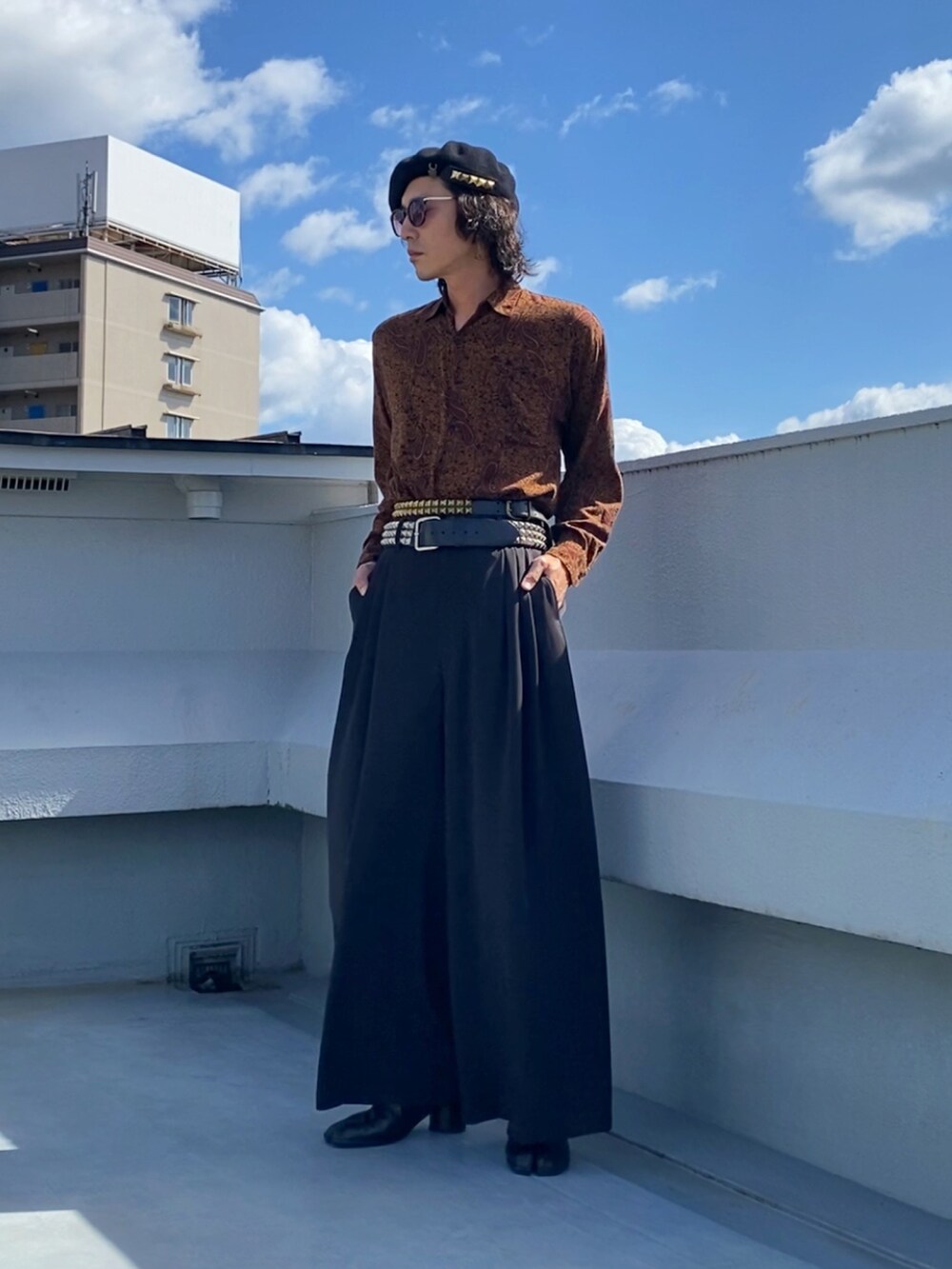 ブラウン系のシャツ/ブラウス、ブラック系のスラックス、ブラック系のブーツを着用したメンズの秋コーディネートの2枚目の写真