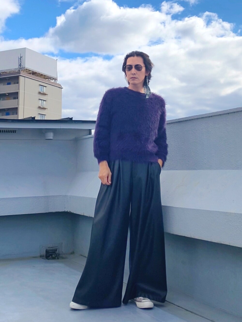 パープル系のニット/セーター、ブラック系のその他パンツ、ベージュ系のスニーカーを着用したメンズの秋コーディネートの3枚目の写真