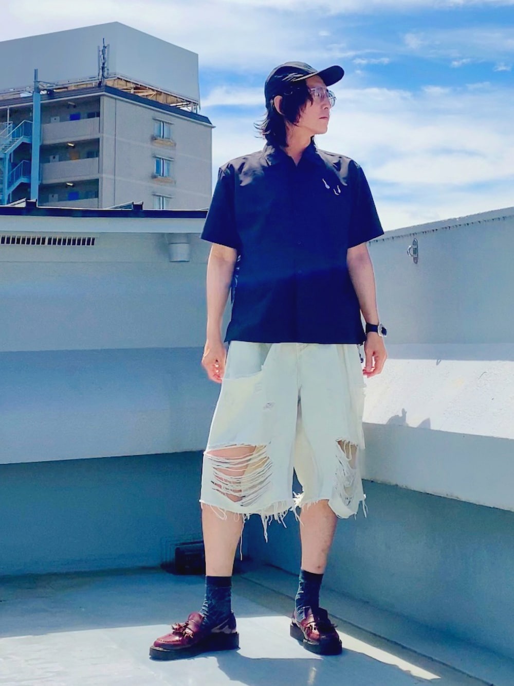 ホワイト系のデニムパンツ、ブラック系のシャツ/ブラウス、レッド系のローファーを着用したメンズの夏コーディネートの5枚目の写真