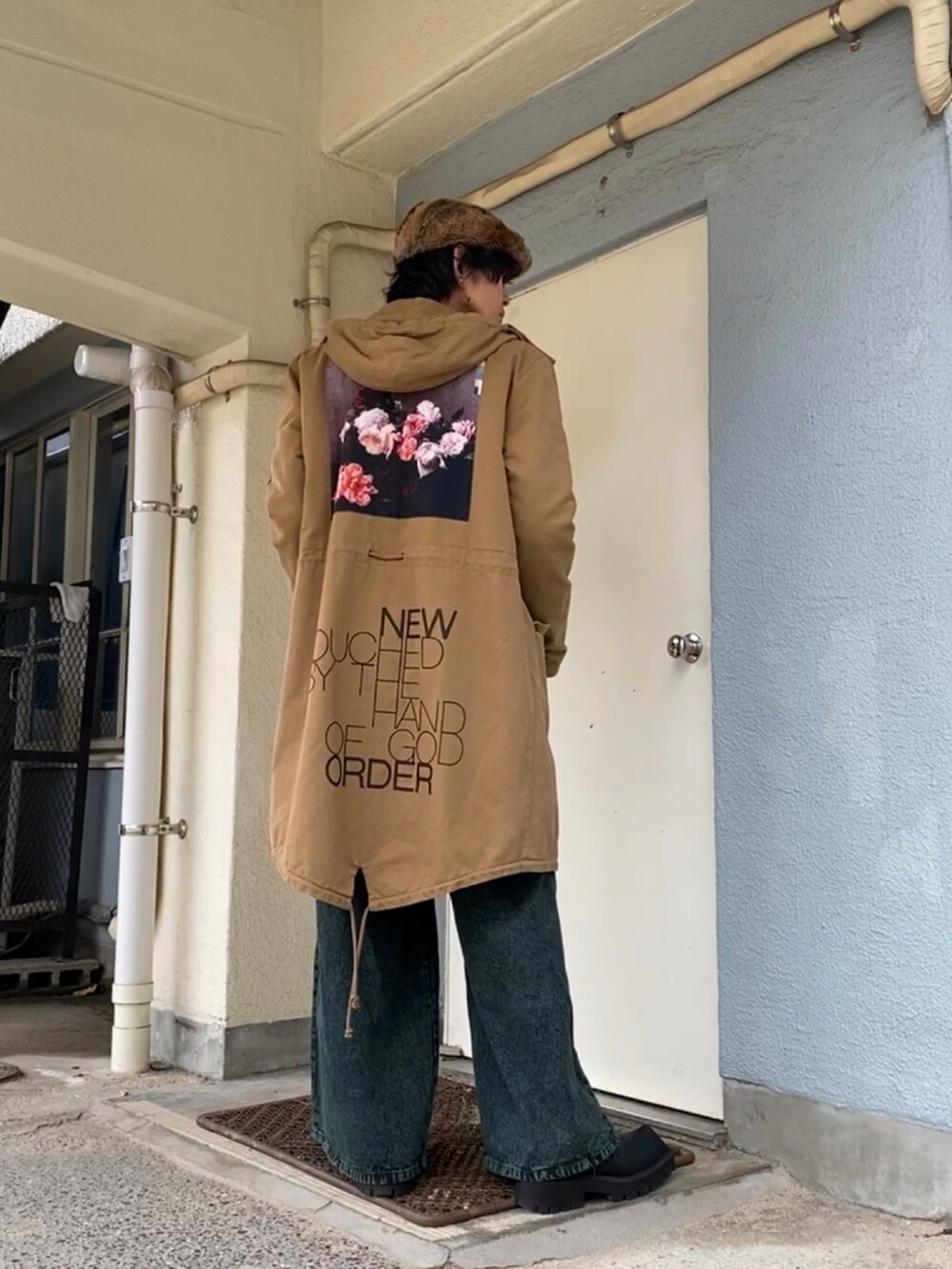 ブラック系のニット/セーター、ベージュ系のモッズコート、グリーン系のデニムパンツを着用したメンズの冬コーディネートの4枚目の写真