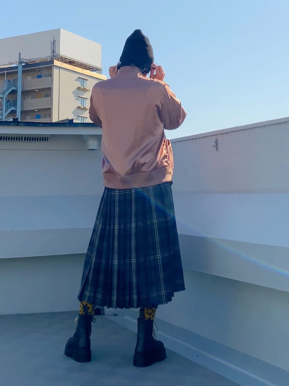 ブラック系のブーツ、パープル系のニット/セーター、ピンク系のMA-1を着用したメンズの冬コーディネートの3枚目の写真