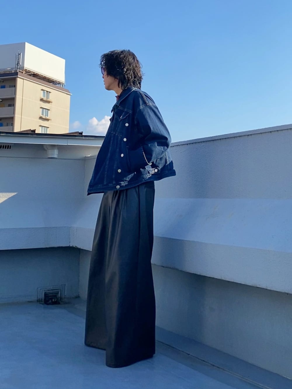 レッド系の蝶ネクタイ、ブルー系のデニムジャケット、ブラック系のその他パンツを着用したメンズの秋コーディネートの3枚目の写真