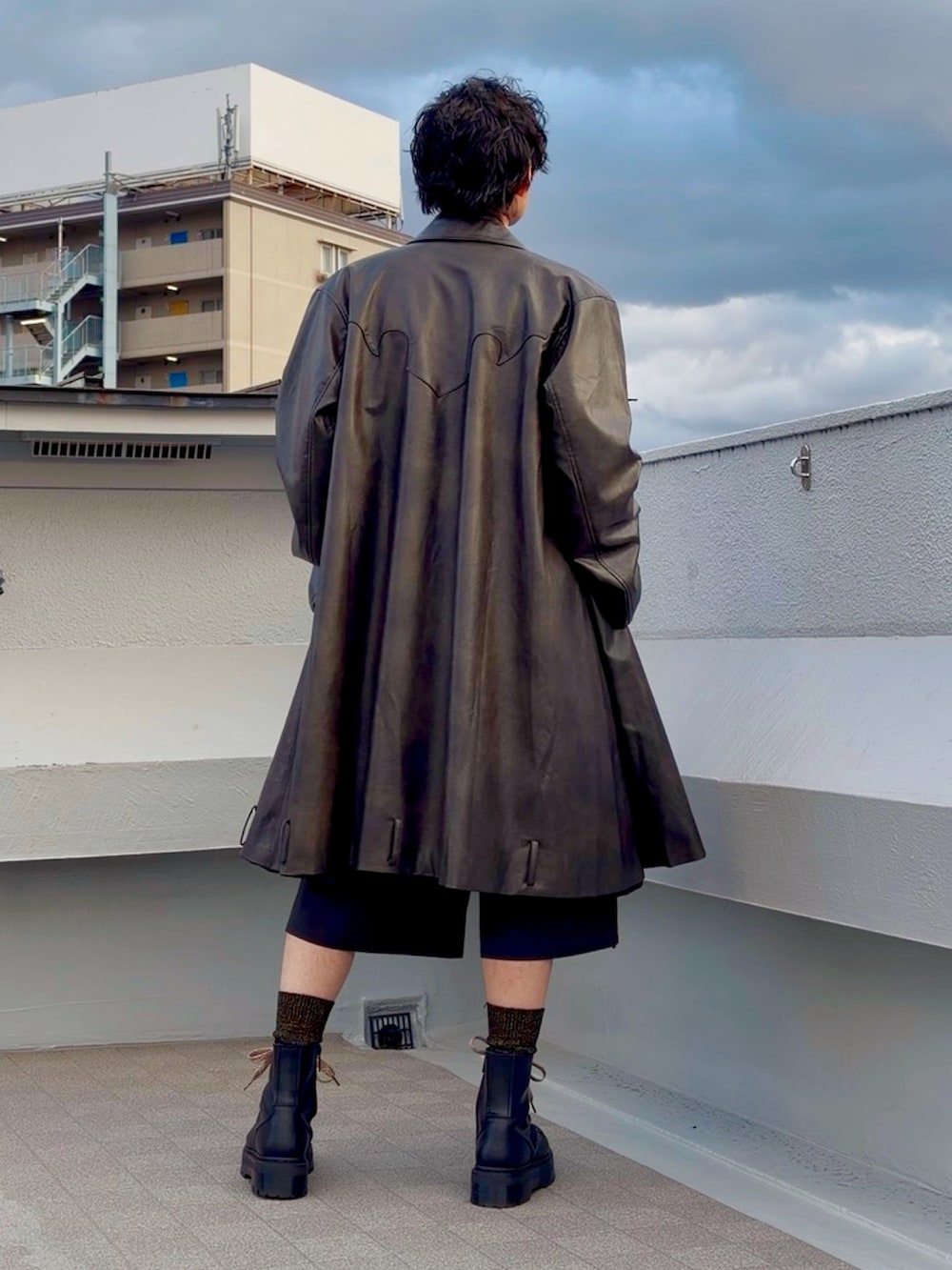 ブラック系のブーツ、ブラック系のニット/セーター、ブラウン系のジャケット/アウターを着用したメンズの冬コーディネートの3枚目の写真