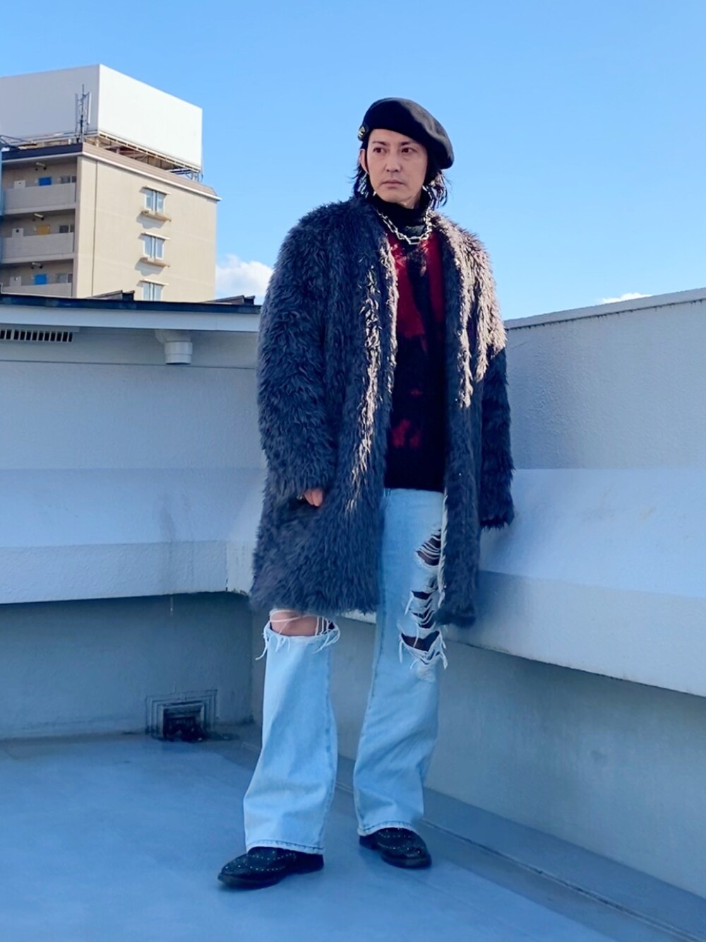 グレー系のノーカラーコート、レッド系のニット/セーター、ブラック系のニット/セーターを着用したメンズの冬コーディネートの5枚目の写真