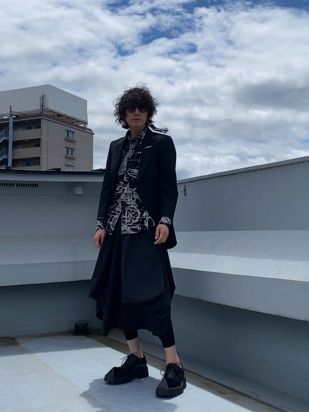 ブラック系のテーラードジャケット、ブラック系のシャツ/ブラウス、ブラック系のスカートを着用したメンズの春コーディネートの4枚目の写真