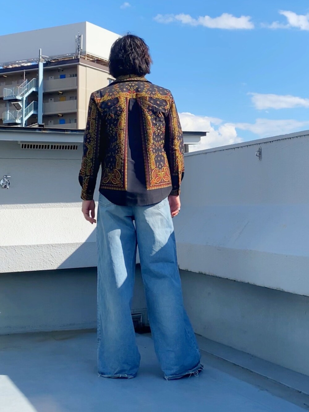 グレー系のTシャツ/カットソー、ブルー系のデニムパンツ、ブラック系のブーツを着用したメンズの秋コーディネートの3枚目の写真