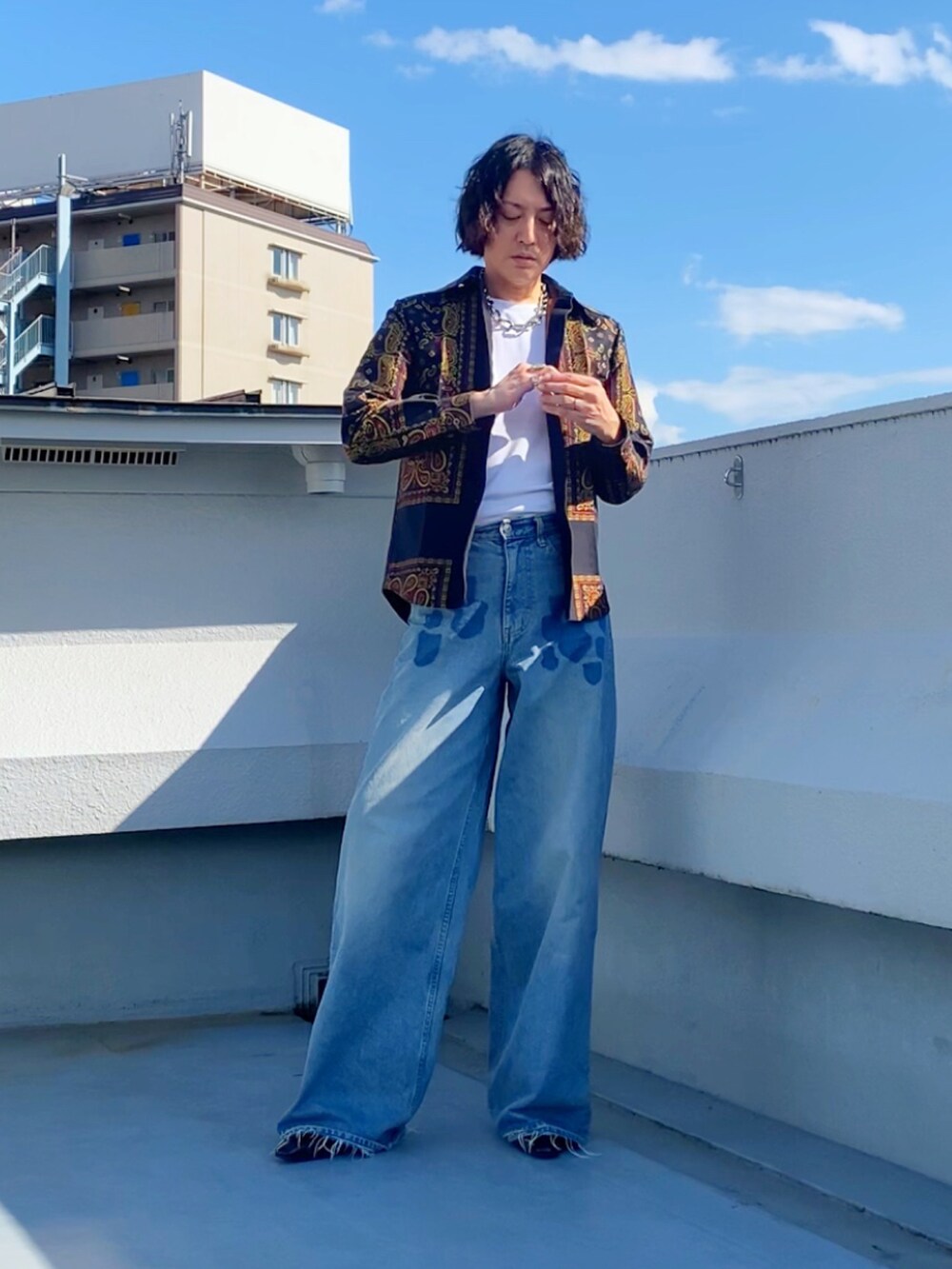 グレー系のTシャツ/カットソー、ブルー系のデニムパンツ、ブラック系のブーツを着用したメンズの秋コーディネートの4枚目の写真