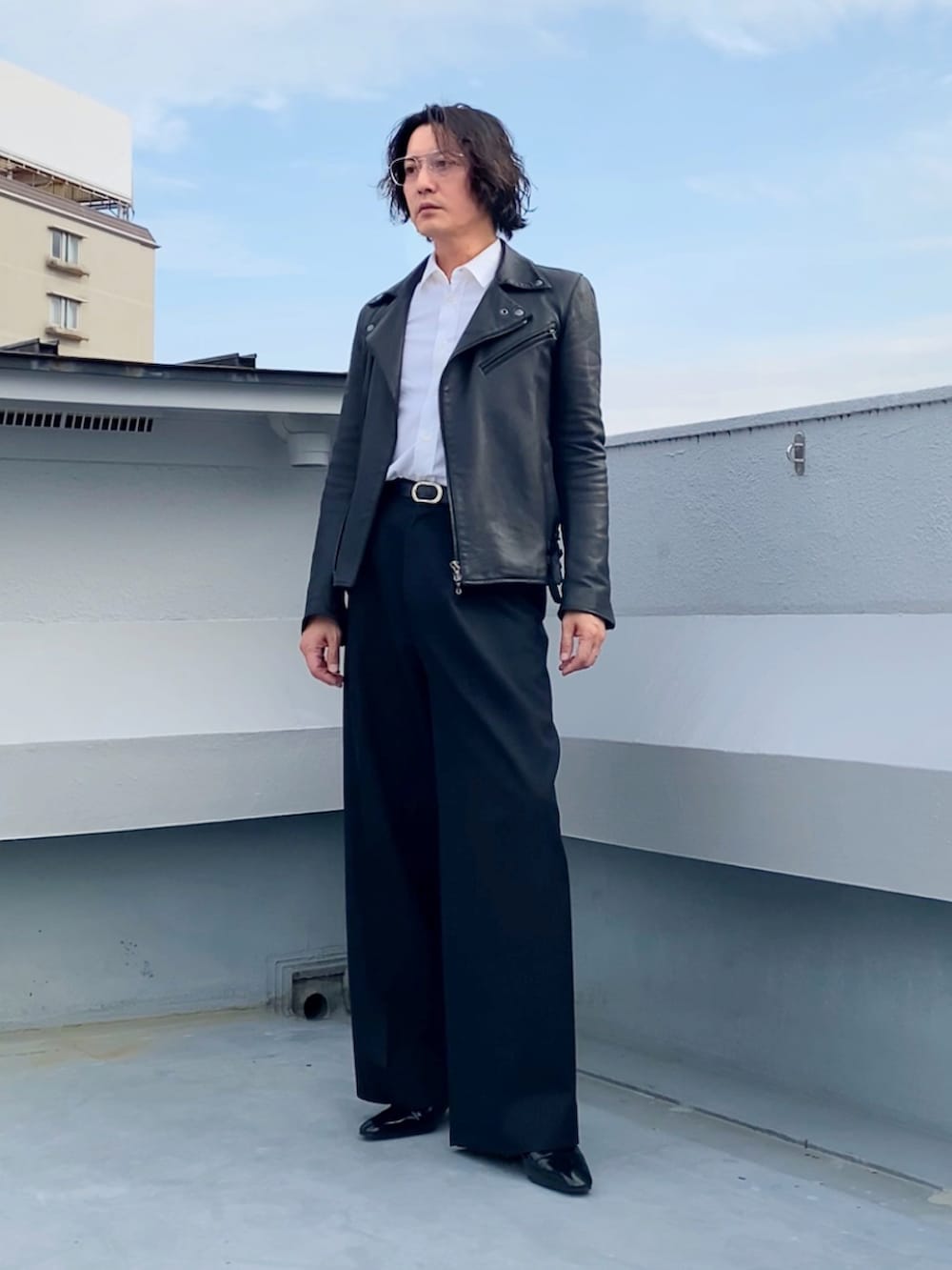 ホワイト系のシャツ/ブラウス、ブラック系のライダースジャケット、ブラック系のスラックスを着用したメンズの秋コーディネートの3枚目の写真