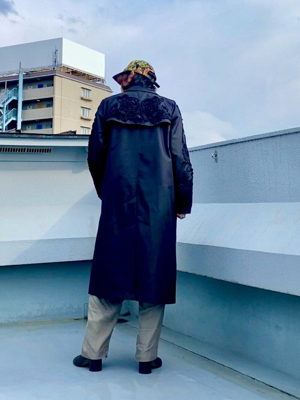 ブラック系のブーツ、ホワイト系のシャツ/ブラウス、ブラック系のステンカラーコートを着用したメンズの春コーディネートの4枚目の写真