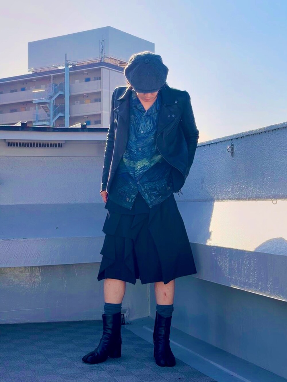 ブルー系のシャツ/ブラウス、ブラック系のブーツ、ブラック系のライダースジャケットを着用したメンズの春コーディネートの2枚目の写真