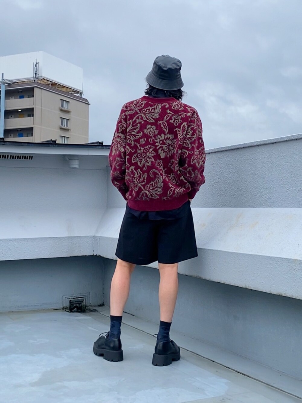 レッド系のカーディガン/ボレロ、ブラック系のシャツ/ブラウス、ブラック系のスラックスを着用したメンズの秋コーディネートの3枚目の写真