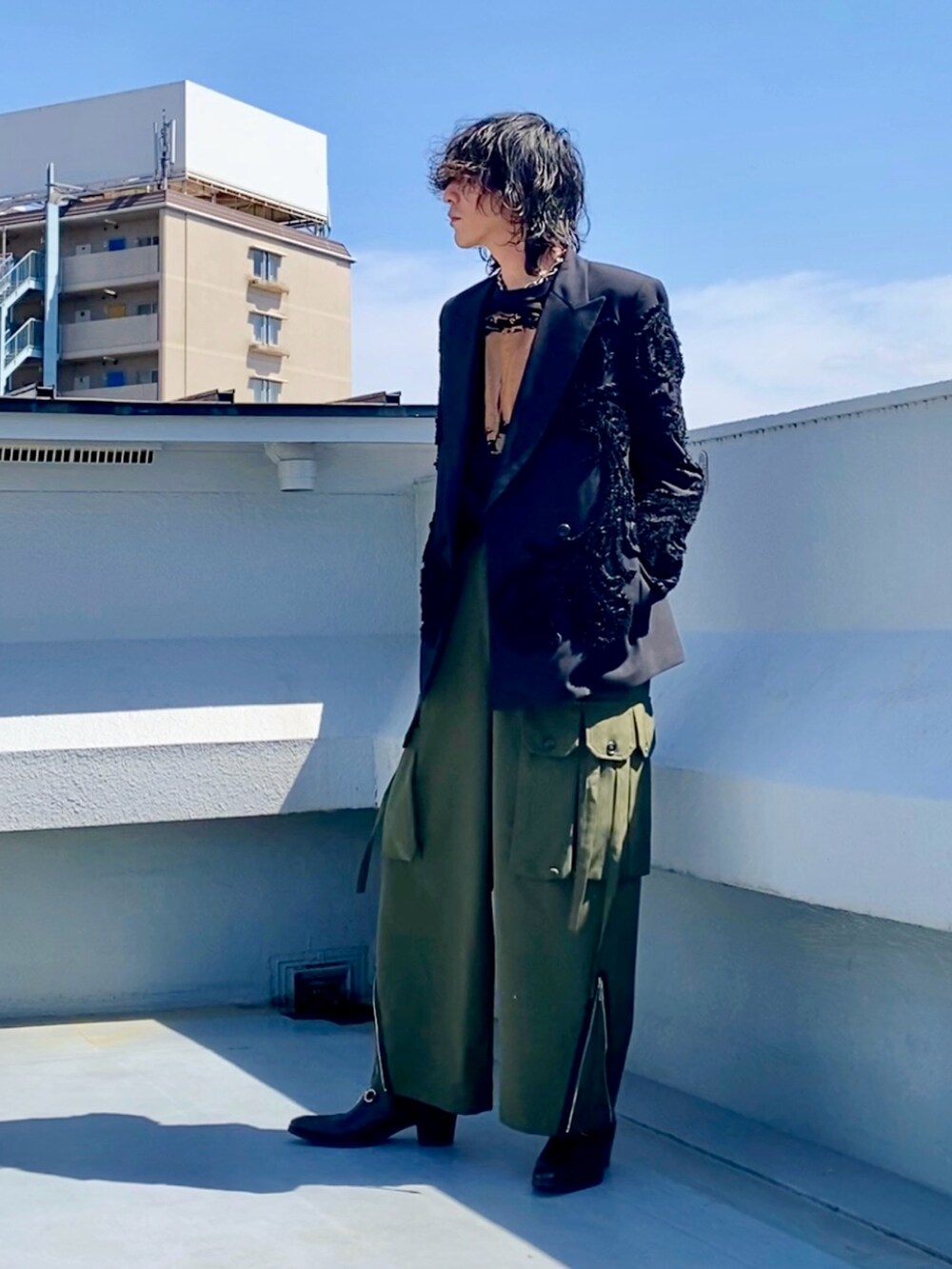 ブラック系のテーラードジャケット、ブラック系のTシャツ/カットソー、グリーン系のカーゴパンツを着用したメンズの春コーディネートの5枚目の写真