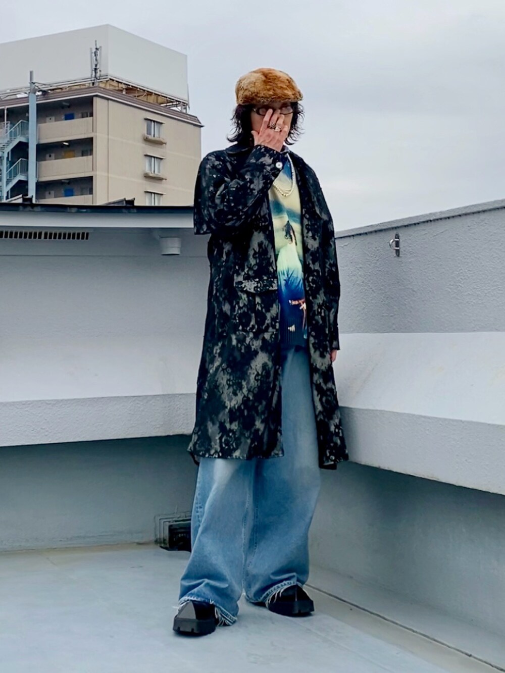 ブラック系のステンカラーコート、ブルー系のニット/セーター、その他のシャツ/ブラウスを着用したメンズの春コーディネートの2枚目の写真