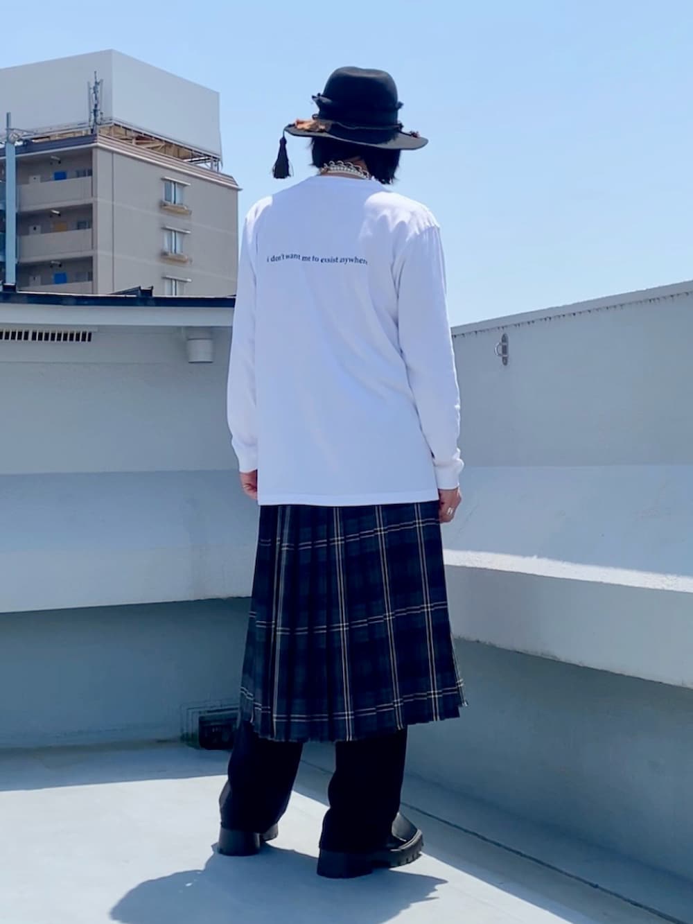 ホワイト系のTシャツ/カットソー、ブラウン系のスカート、ブラック系のスラックスを着用したメンズの春コーディネートの3枚目の写真