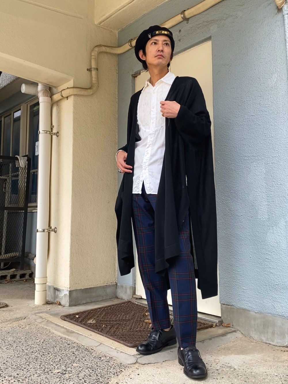 ブラック系のカーディガン/ボレロ、グリーン系のスラックス、ブラック系のドレスシューズを着用したメンズの秋コーディネートの3枚目の写真