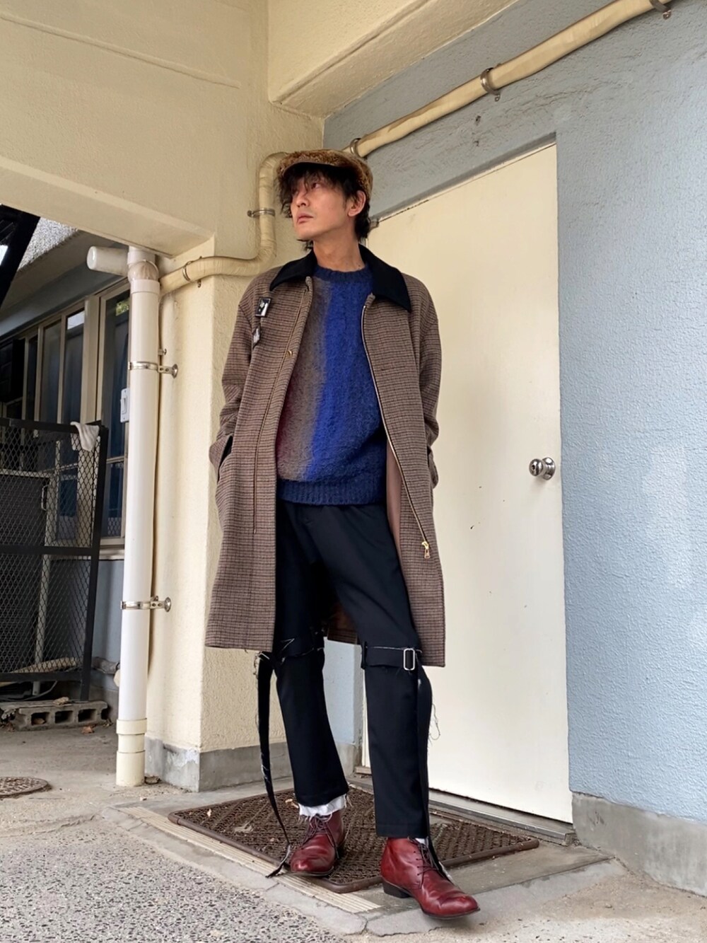 ブルー系のニット/セーター、ブラック系のその他パンツ、レッド系のドレスシューズを着用したメンズの冬コーディネートの3枚目の写真