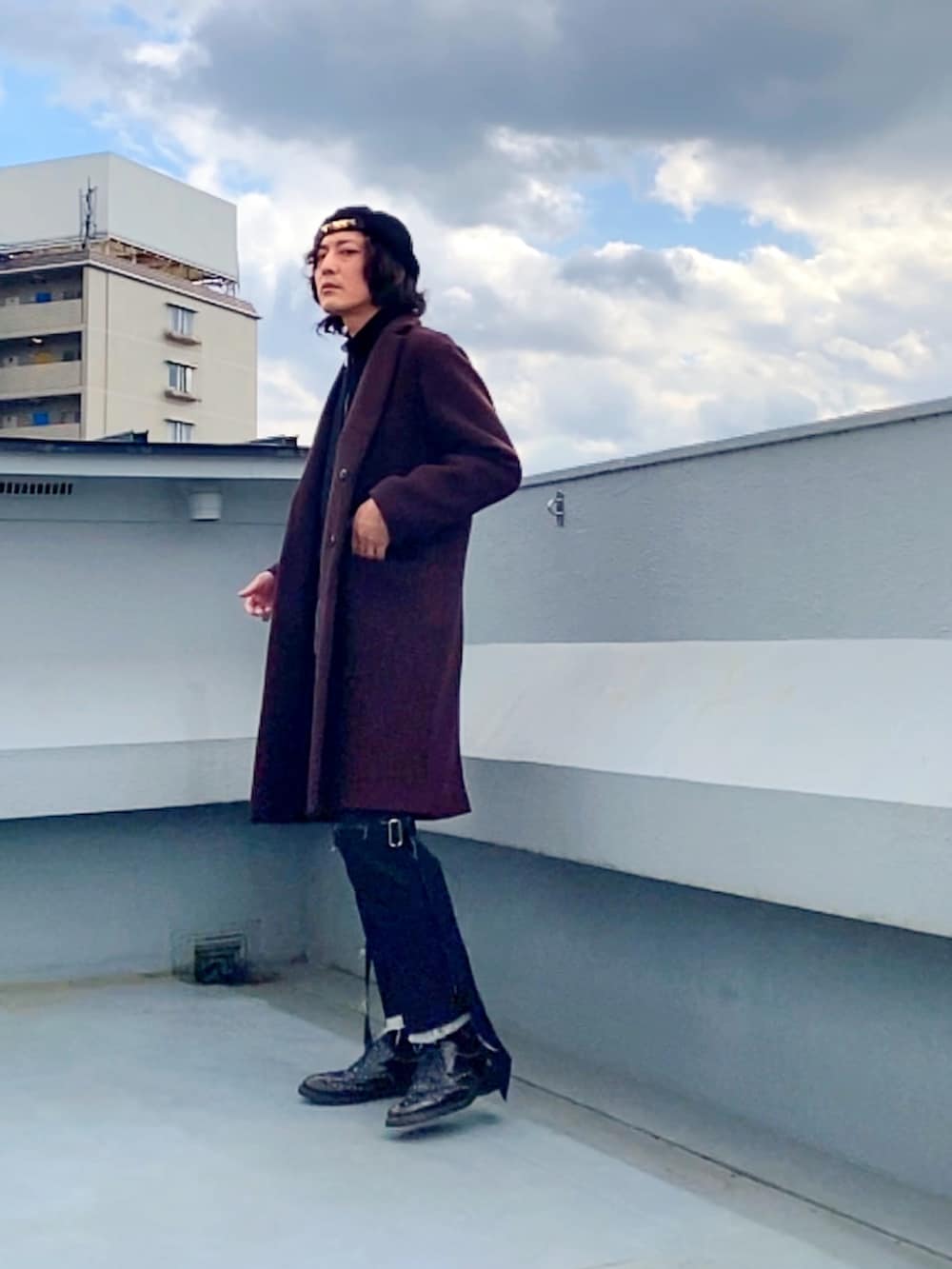 レッド系のチェスターコート、ブラック系のニット/セーター、ブラック系のその他パンツを着用したメンズの冬コーディネートの2枚目の写真