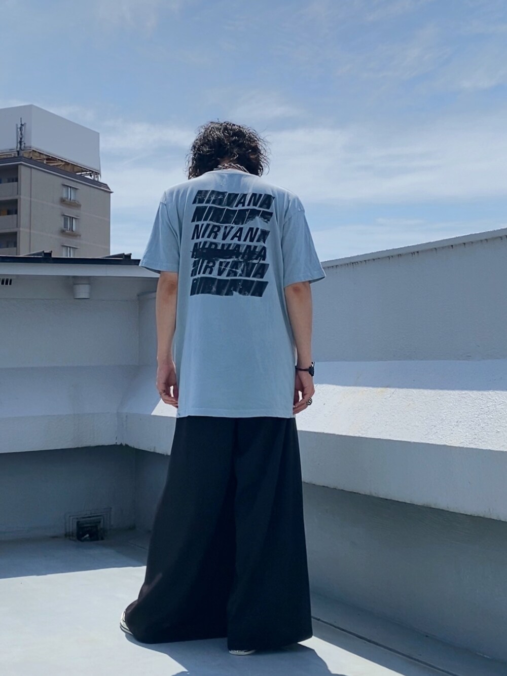 グリーン系のTシャツ/カットソー、ブラック系のスラックス、ベージュ系のスニーカーを着用したメンズの夏コーディネートの5枚目の写真