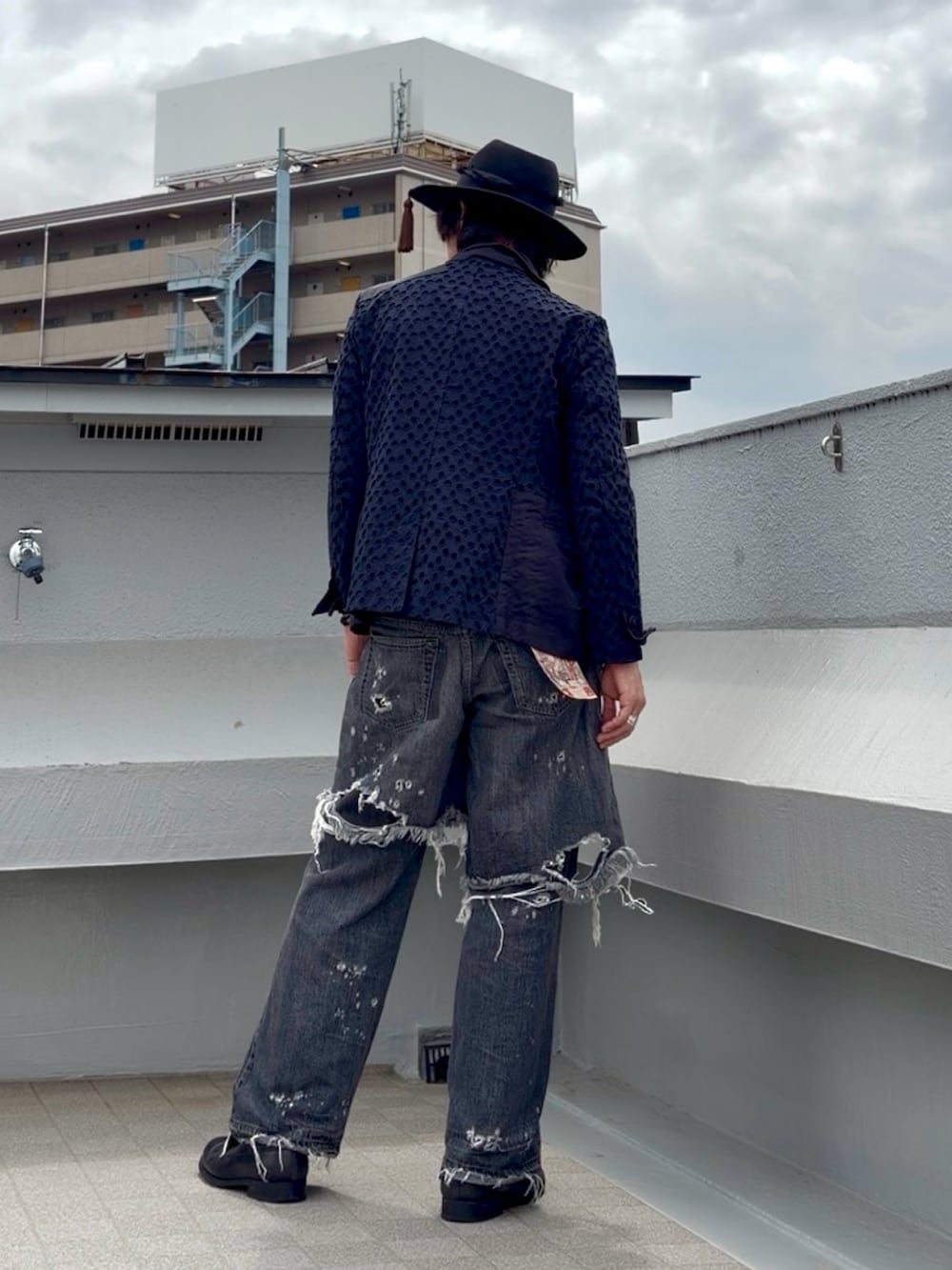 ブラック系のTシャツ/カットソー、ブルー系のテーラードジャケット、ブラック系のデニムパンツを着用したメンズの夏コーディネートの4枚目の写真