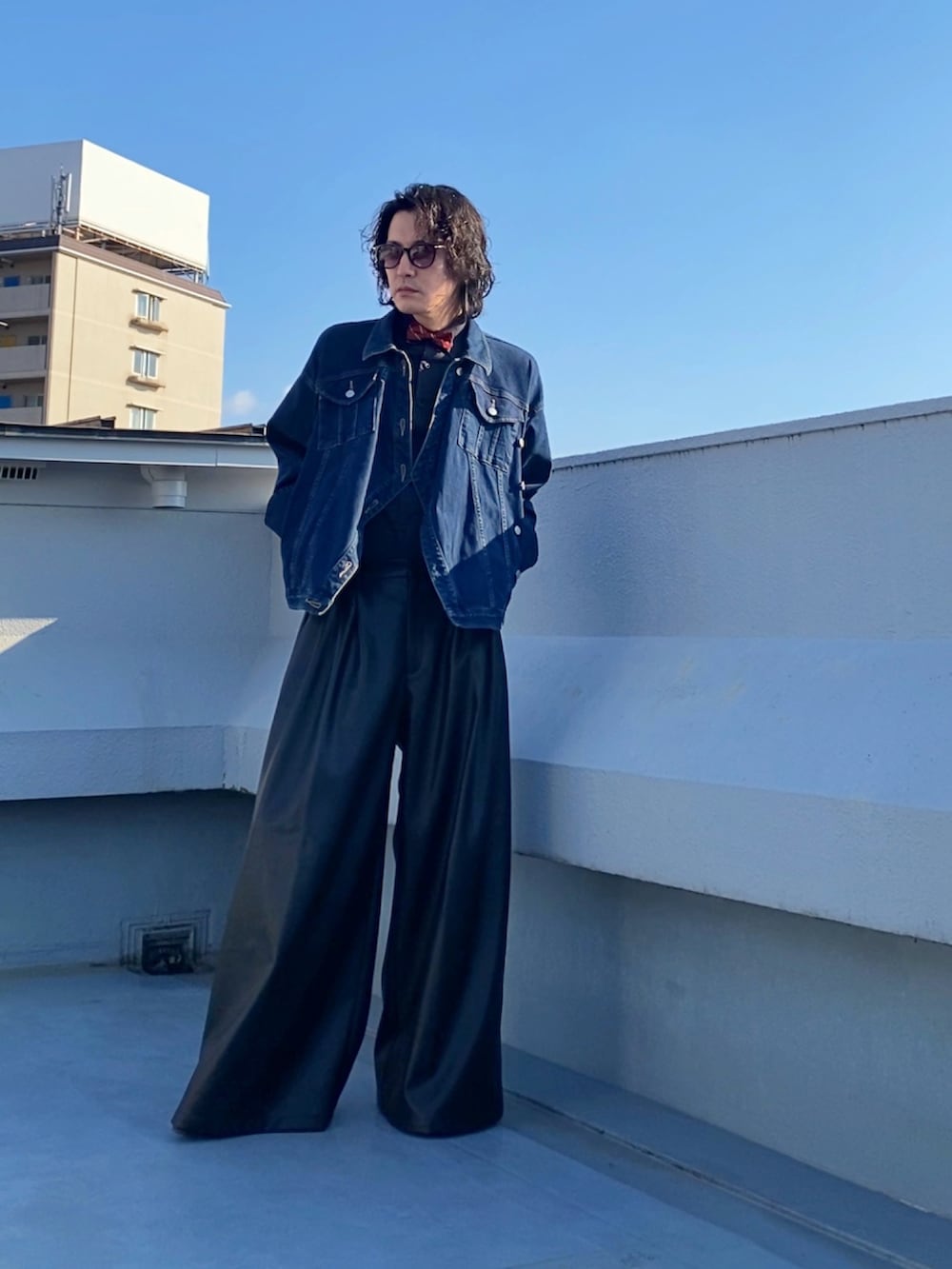 レッド系の蝶ネクタイ、ブルー系のデニムジャケット、ブラック系のその他パンツを着用したメンズの秋コーディネートの2枚目の写真