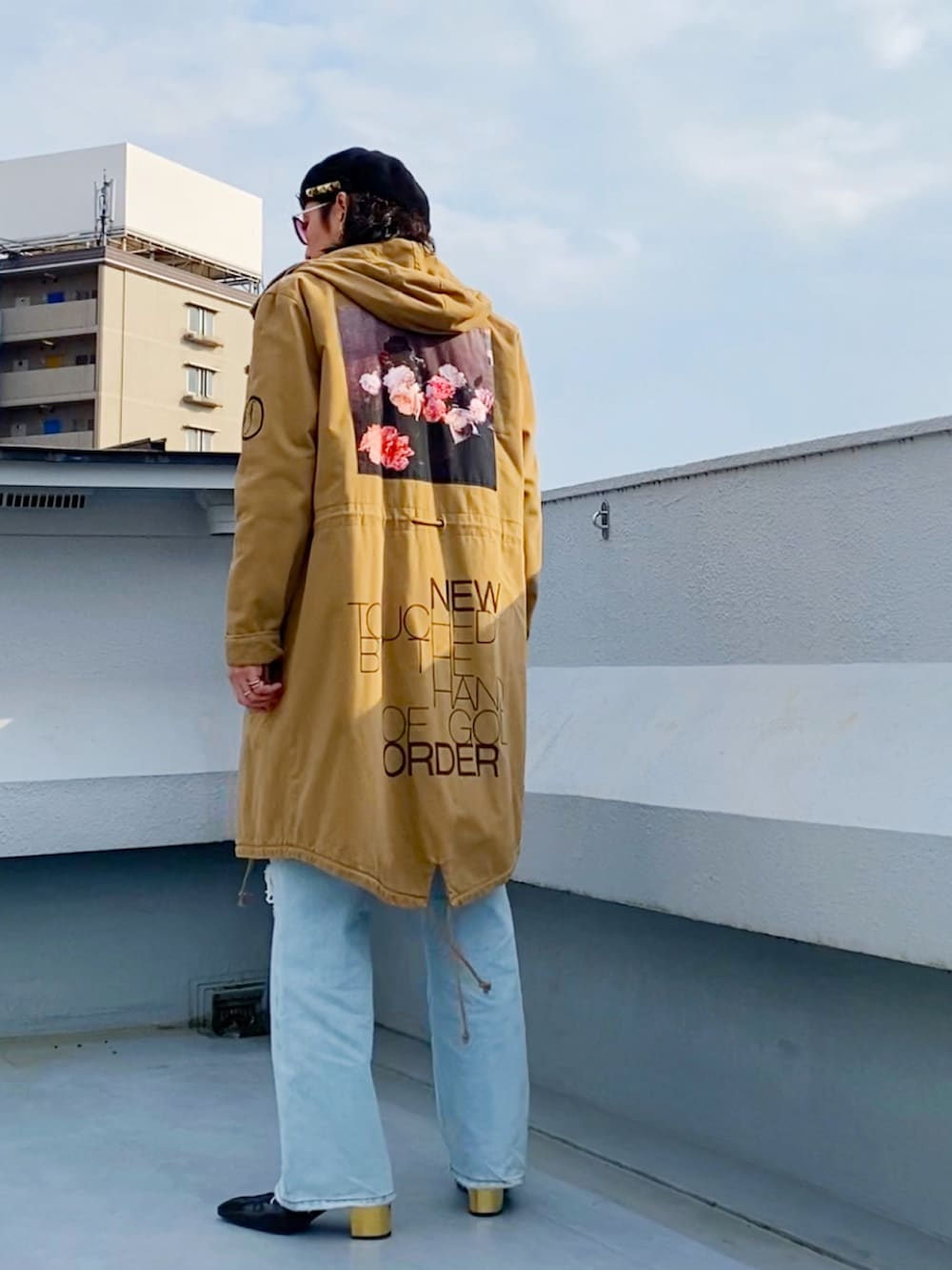 ベージュ系のモッズコート、ブラック系のニット/セーター、ブルー系のデニムパンツを着用したメンズの冬コーディネートの2枚目の写真