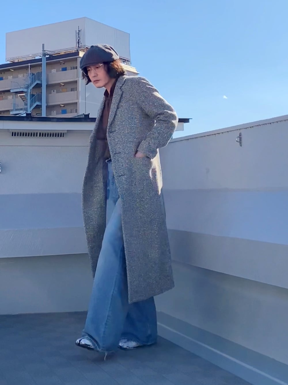 ブルー系のデニムパンツ、ブラウン系のシャツ/ブラウス、ベージュ系のチェスターコートを着用したメンズの秋コーディネートの4枚目の写真