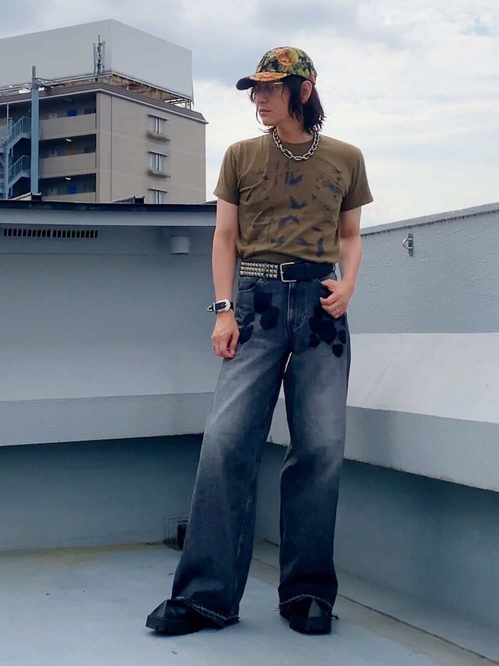ブラック系のデニムパンツ、ベージュ系のTシャツ/カットソー、ブラック系のドレスシューズを着用したメンズの夏コーディネートの3枚目の写真