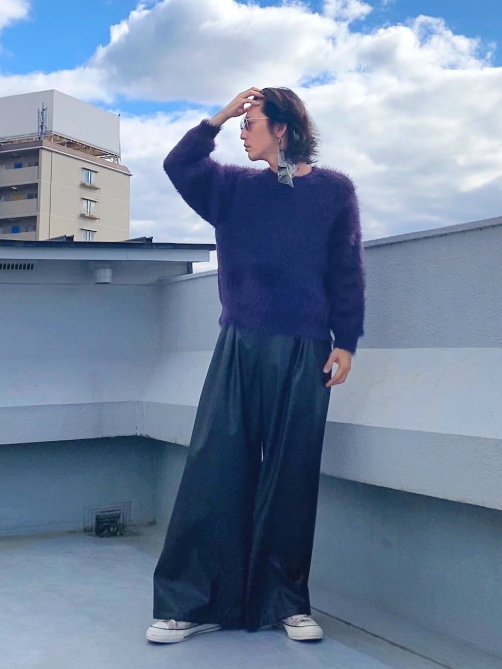 パープル系のニット/セーター、ブラック系のその他パンツ、ベージュ系のスニーカーを着用したメンズの秋コーディネートの2枚目の写真